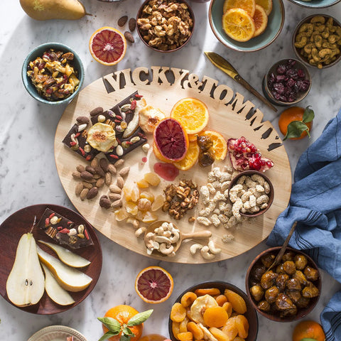 Maple Oval Personalized Wood Cutting Board with words Vicky & Tony cut out along top. Board is covered with fruit and nuts.