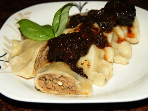 Pierogi stuffed with duck and topped with plum sauce