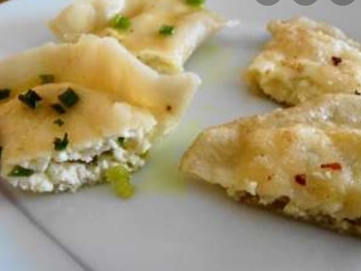 Potato and onion pierogi topped with sour cream