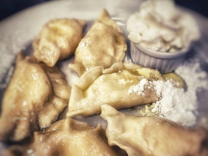 Potato and onion pierogi topped with sour cream