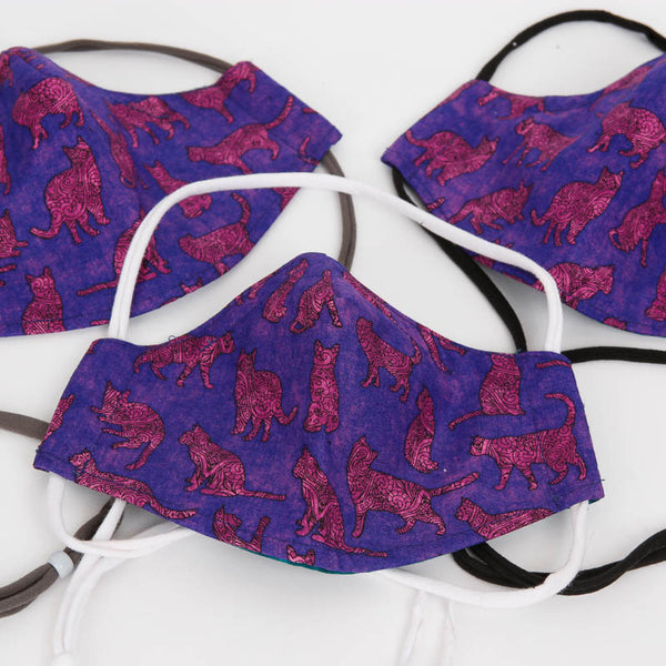 Size medium reversible face mask made with a purple cats fabric. The masks have adjustable head straps or ear loops. Made in the USA.