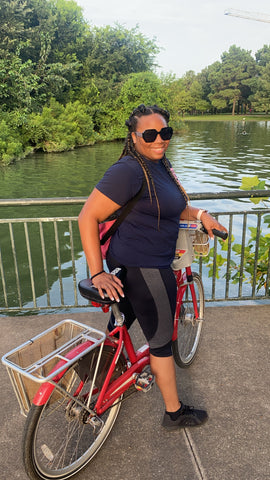 Aura of Opulence's CEO poses with a bike in Hermann Park, Houston, TX
