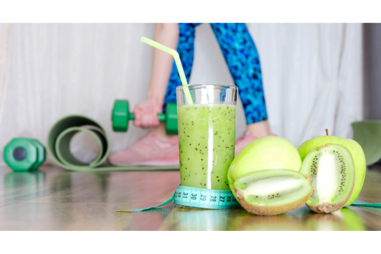 Green smoothie next to workout weights