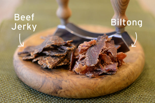 Beef Jerky and biltong on wood table with knife.