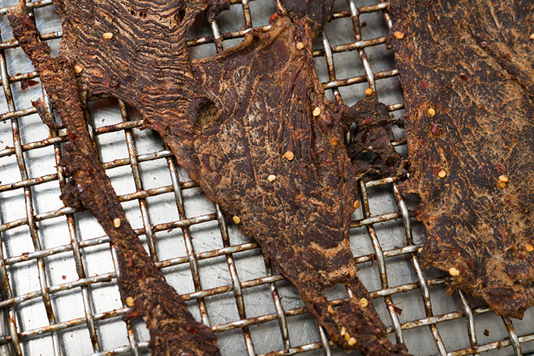 Dried jerky on a metal rack 