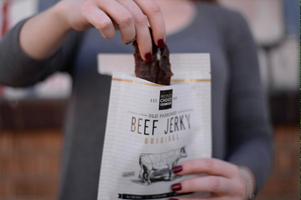 Someone opening a bag of Old Fashioned Beef Jerky Bag