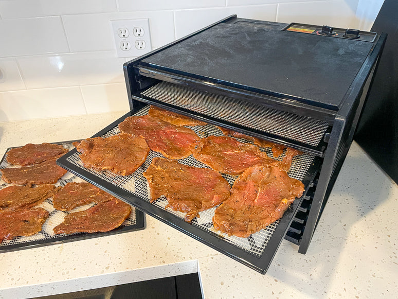 Dehydrating beef jerky in a dehydrator.