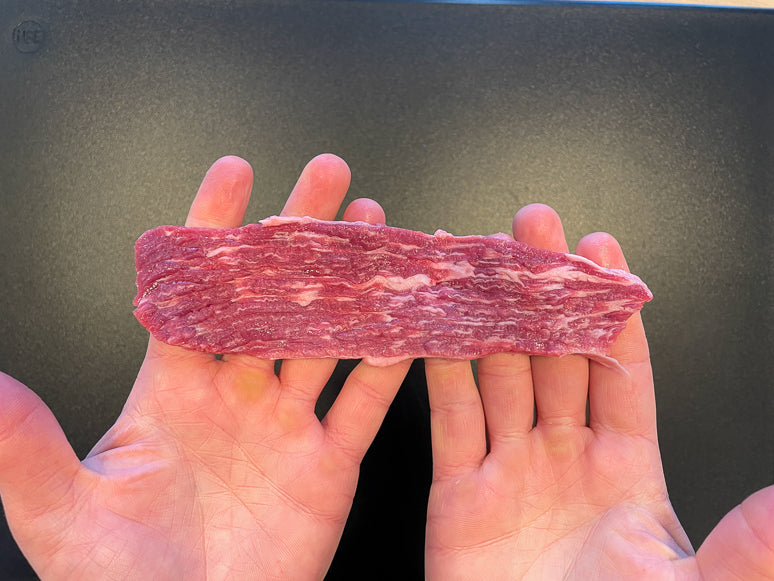 A piece of meat sliced with the grain.
