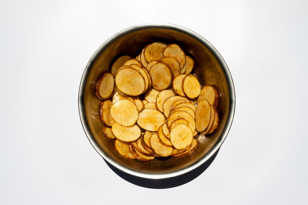 Sliced potatoes tossed with olive oil and seasoning