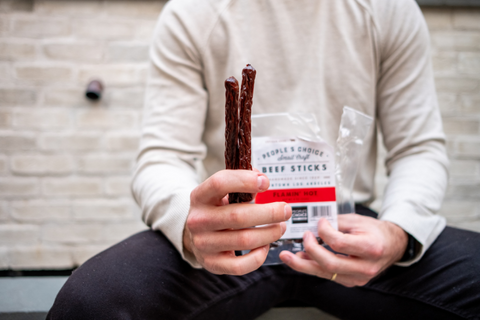 Man holding Flamin Hot Beef Sticks