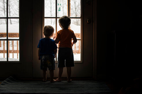 Two kids looking out the window