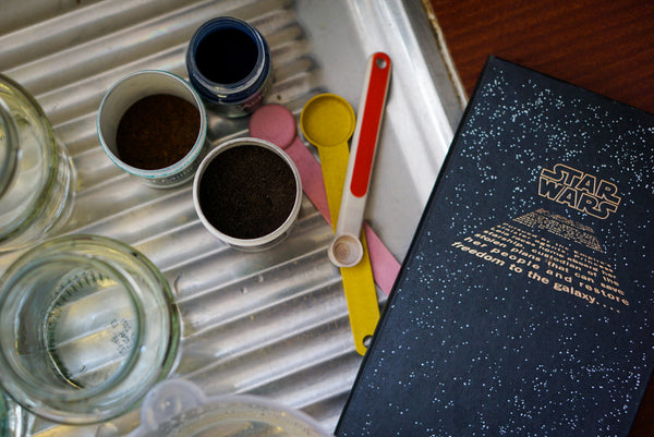 Dye powders, measuring cups, dye stock containers, and a notebook, ready for a dyeing session