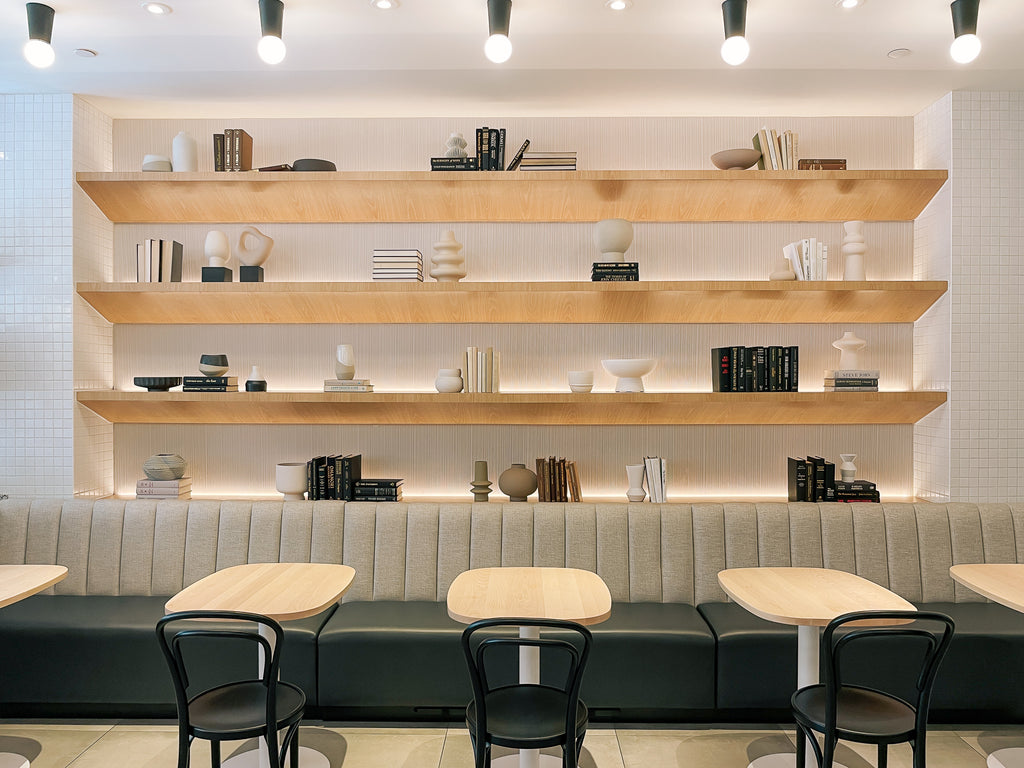 Photo of a cafe with custom made tables all in maple, with a modern clean look. Bright and airy curated space.