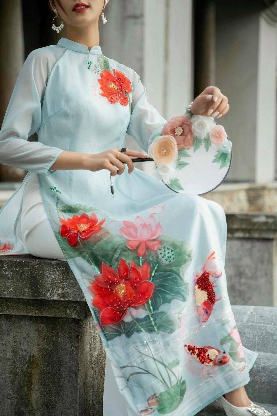 Sự kết hợp giữá màu xanh ngọc bích và họa tiết hoa sen trên bộ đồ Sparkle Blue Lotus Ao Dai Set sẽ khiến bạn trông thật nổi bật và quyến rũ. Những viên pha lê Swarovski được dùng để trang trí thêm phần sặc sỡ. Xem hình ảnh để khám phá thêm nét độc đáo của chiếc áo dài thanh lịch này.