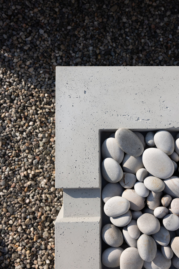 Hauser Avera fireplace with Ivory stones, a concrete structure, on a pea stone base