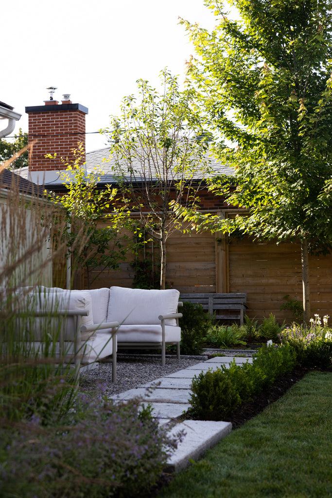 modern concrete stepping stones leading to shade garden with water feature