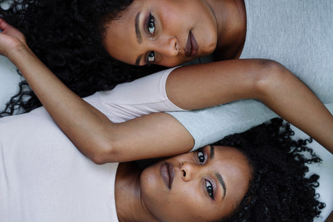 Naelle studio pay it forward image. Two Black Women laying down side by side