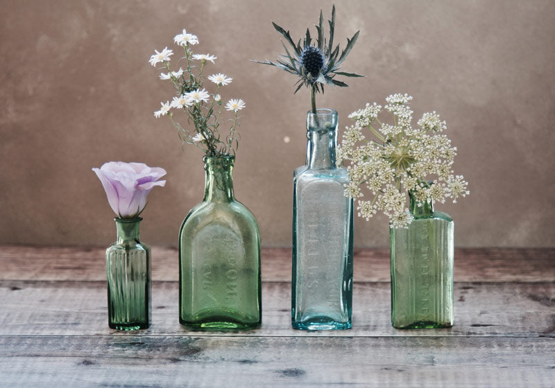 Flowers in coloured glass bud vases