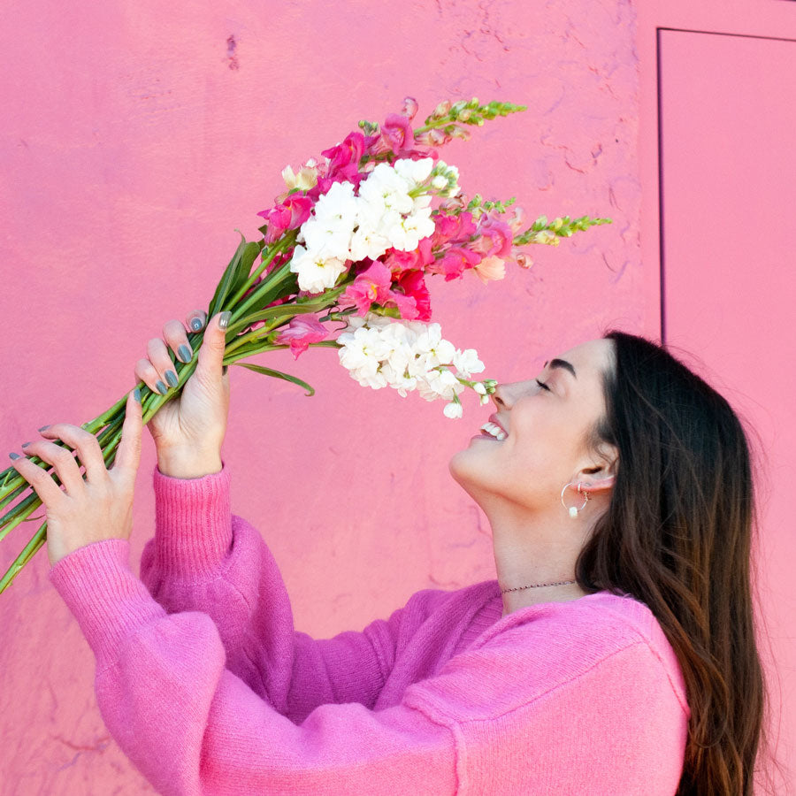 Woman holding and smelling fresh snapdragon flowers