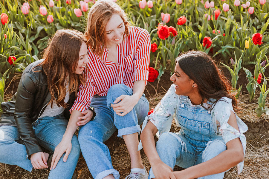 Women sitting smiling in a flower field