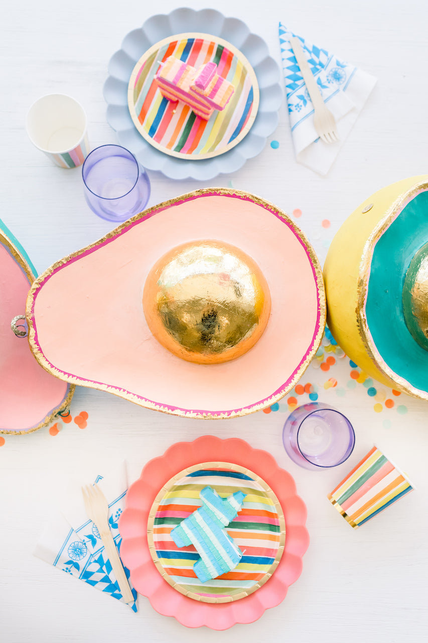 Bright fiesta themed tableware and an avocado centerpiece for a Cinco de Mayo party. 