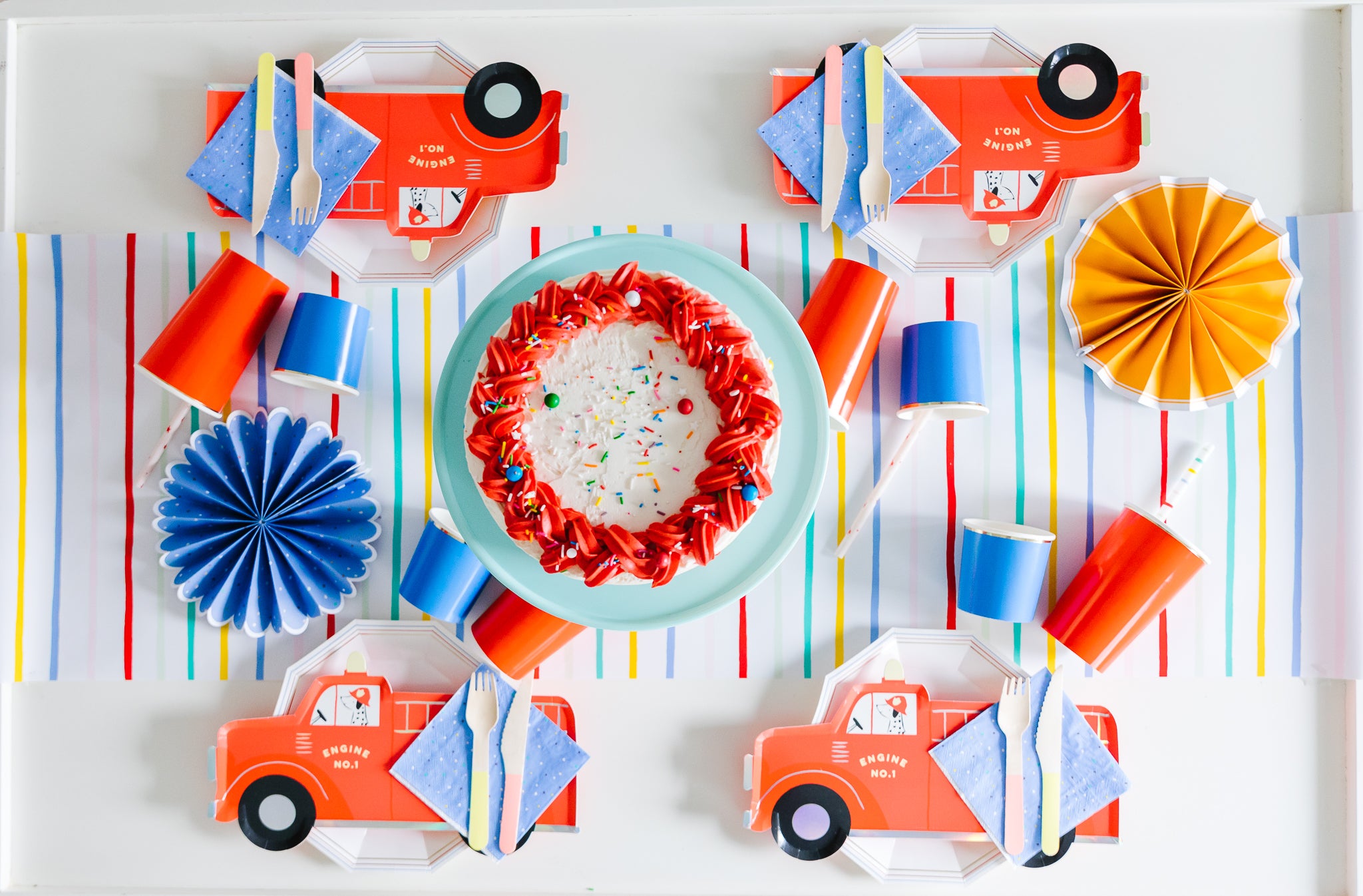 Flatlay of fire truck party supplies for first birthday party ideas