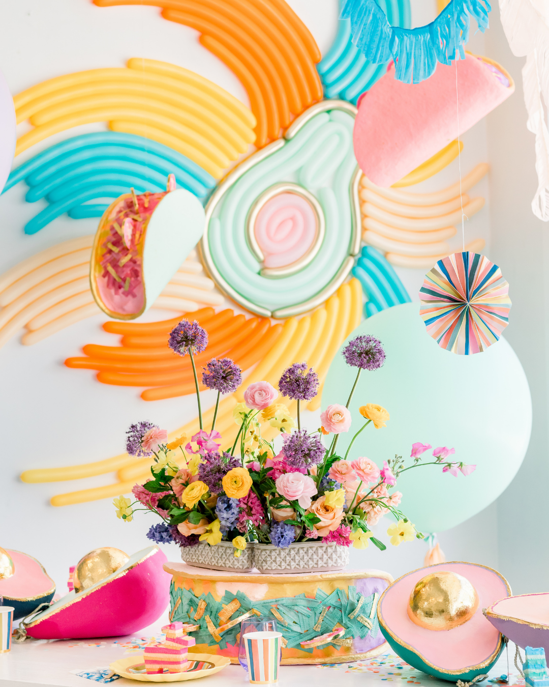 Colorful avocado balloon installation with other Mexican fiesta decorations for a Cinco de Mayo party.