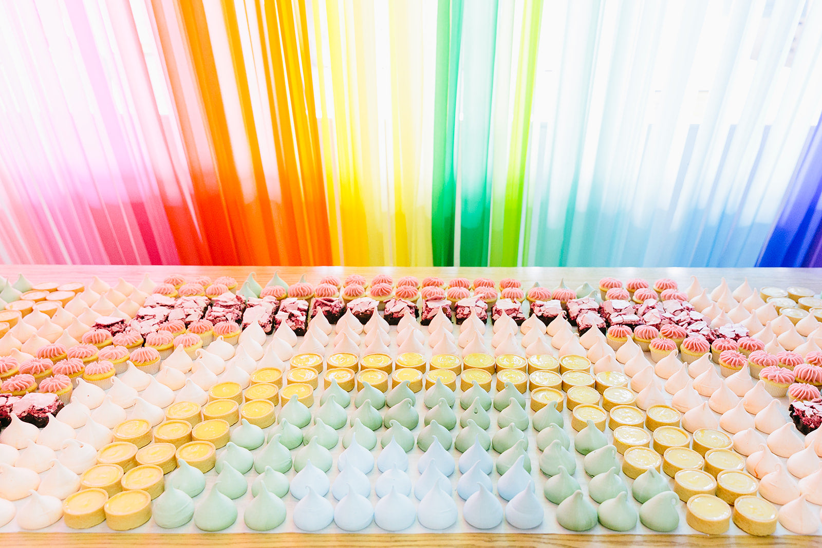 Rainbow treats set out for a rainbow dessert table idea.