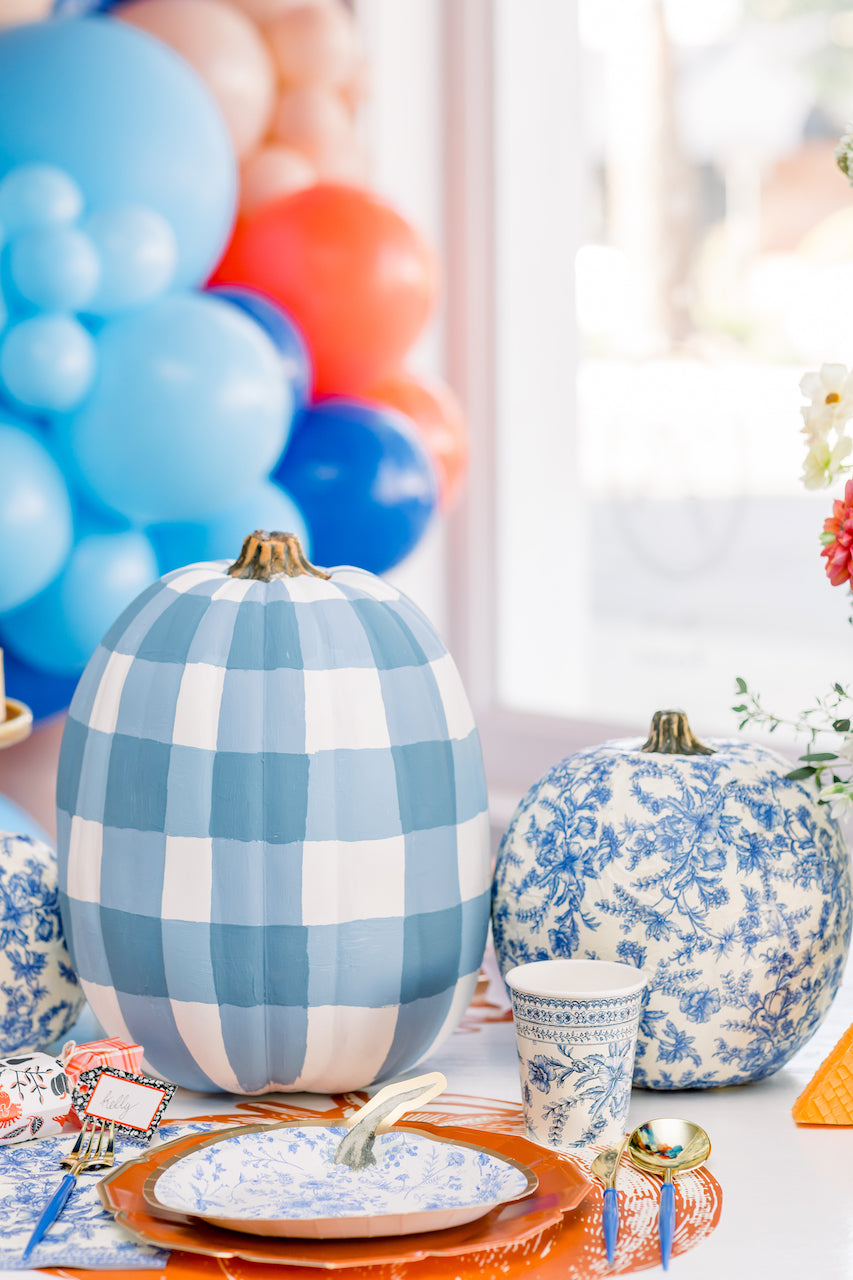 Thanksgiving party table setting with colorful balloon backdrop.