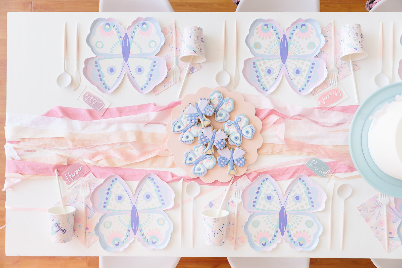 Butterfly party plates, napkins, and cups displayed on a butterfly birthday party table. 