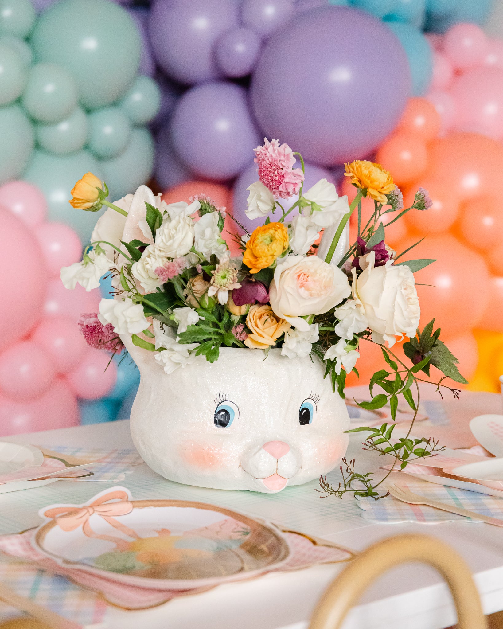 Easter bunny bucket with flowers used as an Easter table centerpiece.
