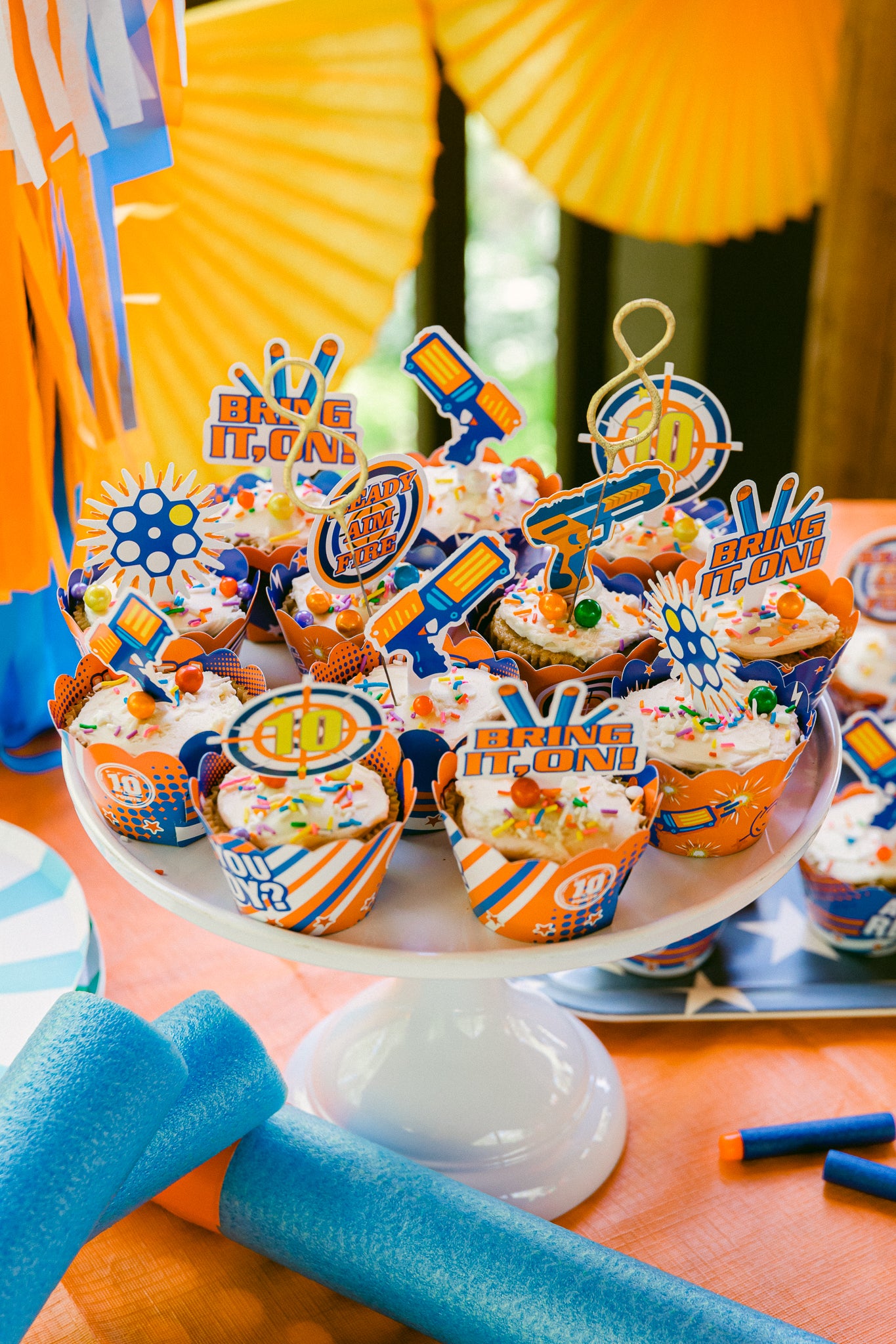 Nerf birthday party cupcakes with matching toppers and wrappers.