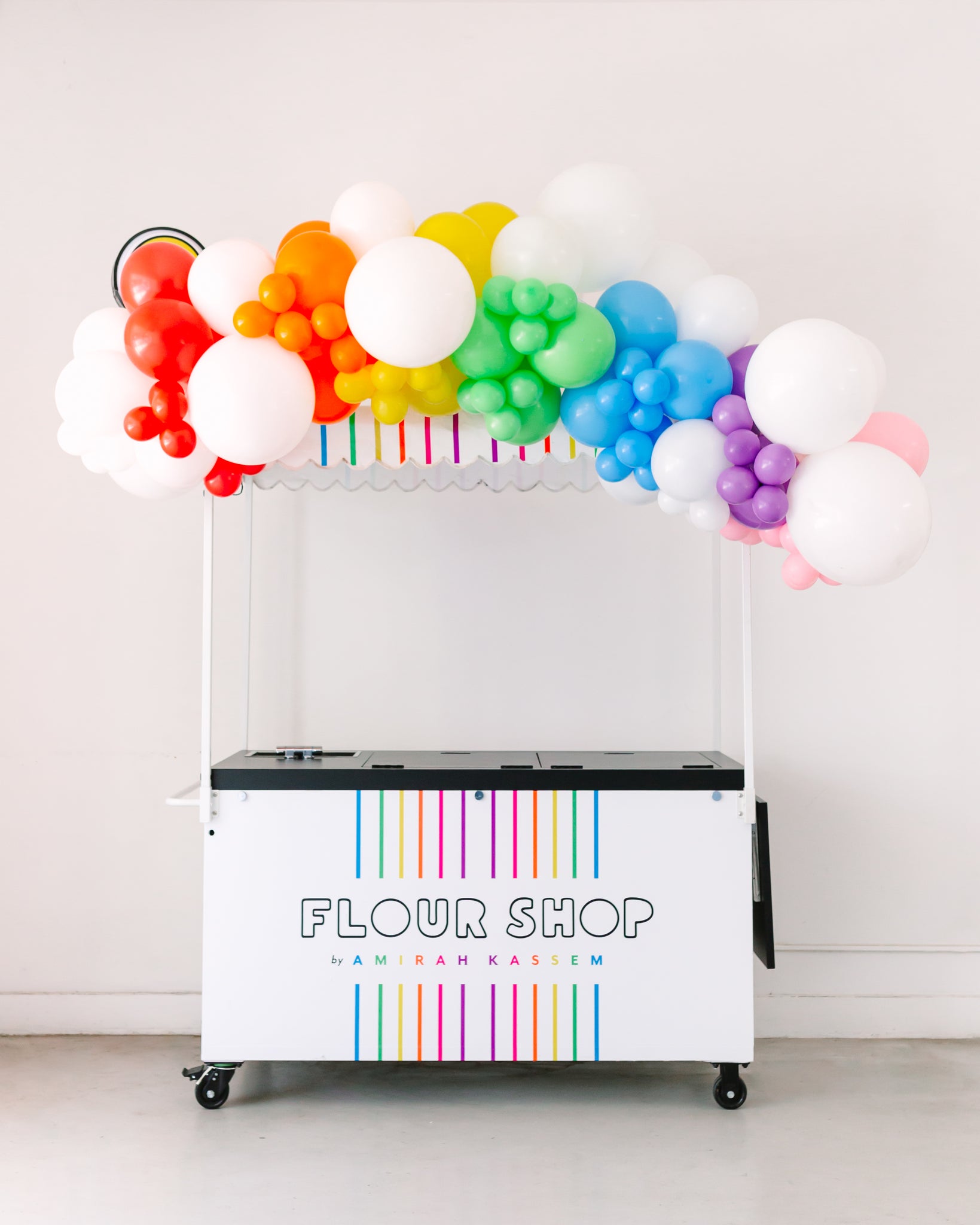 Rainbow balloon decoration ideas for a dessert catering cart.