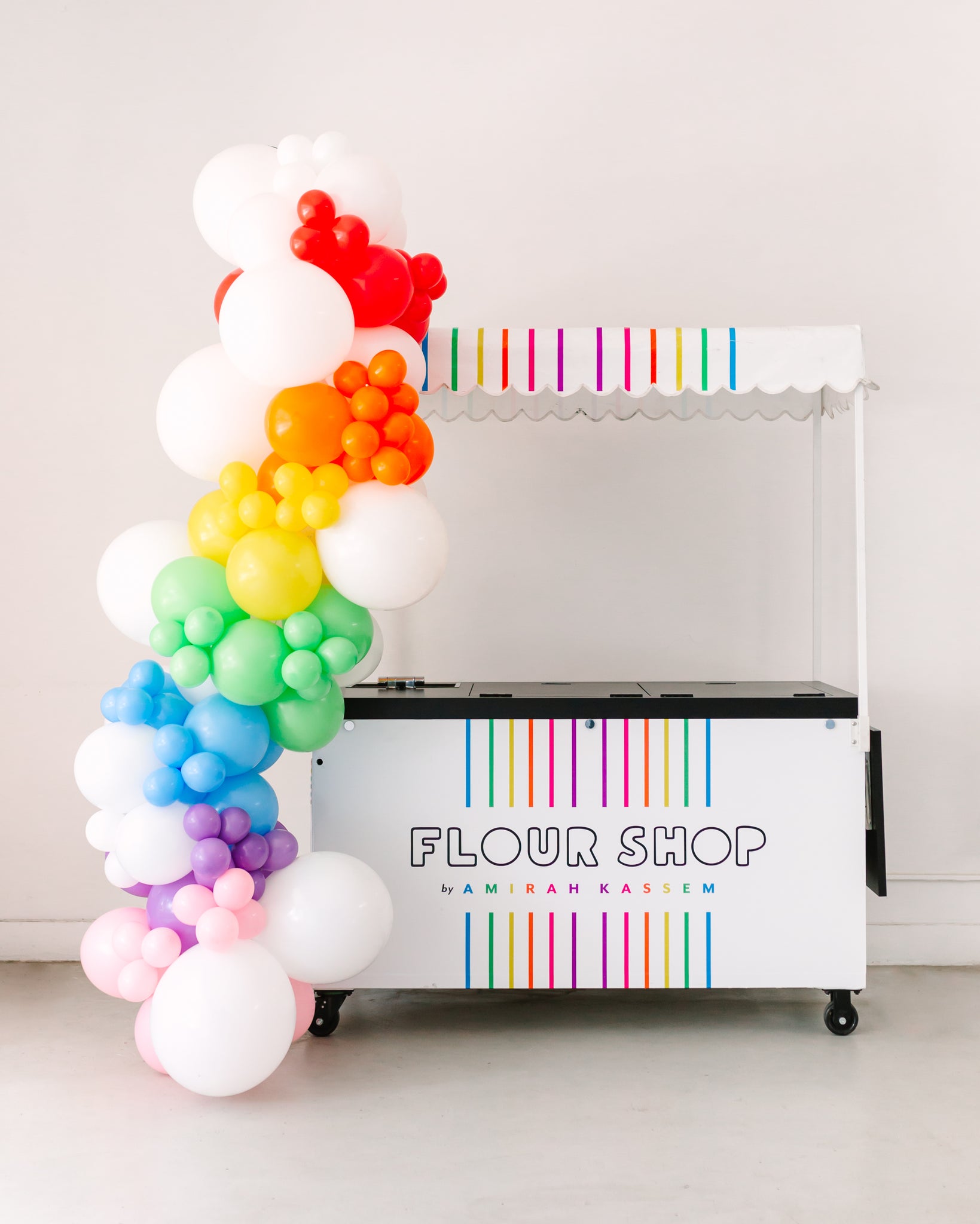 Rainbow balloon arch decoration for a treat cart. 
