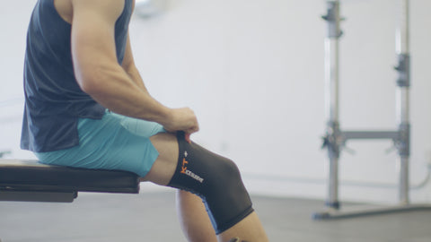 Man applying ice sleeve to knee after a workout