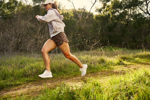 woman trail running with KT tape