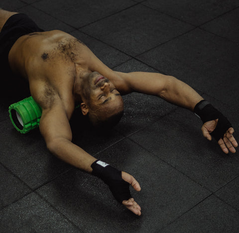 man laying on foam roller to release back muscles