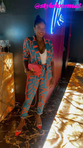 Natalie Robinson of styleiconnat at a London bar with the pink FLORE QUO Iris bag