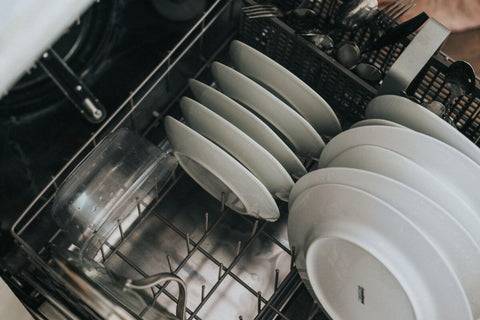 A photo of an eco-friendly dishwasher being filled with white plates