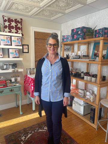 woman standing with a smile and glasses in jeans and a blouse with a sweater