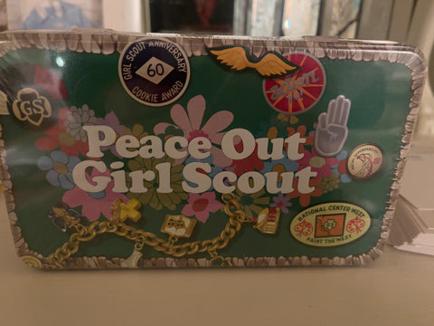 tin candy box that says "Peace Out Girl Scout"