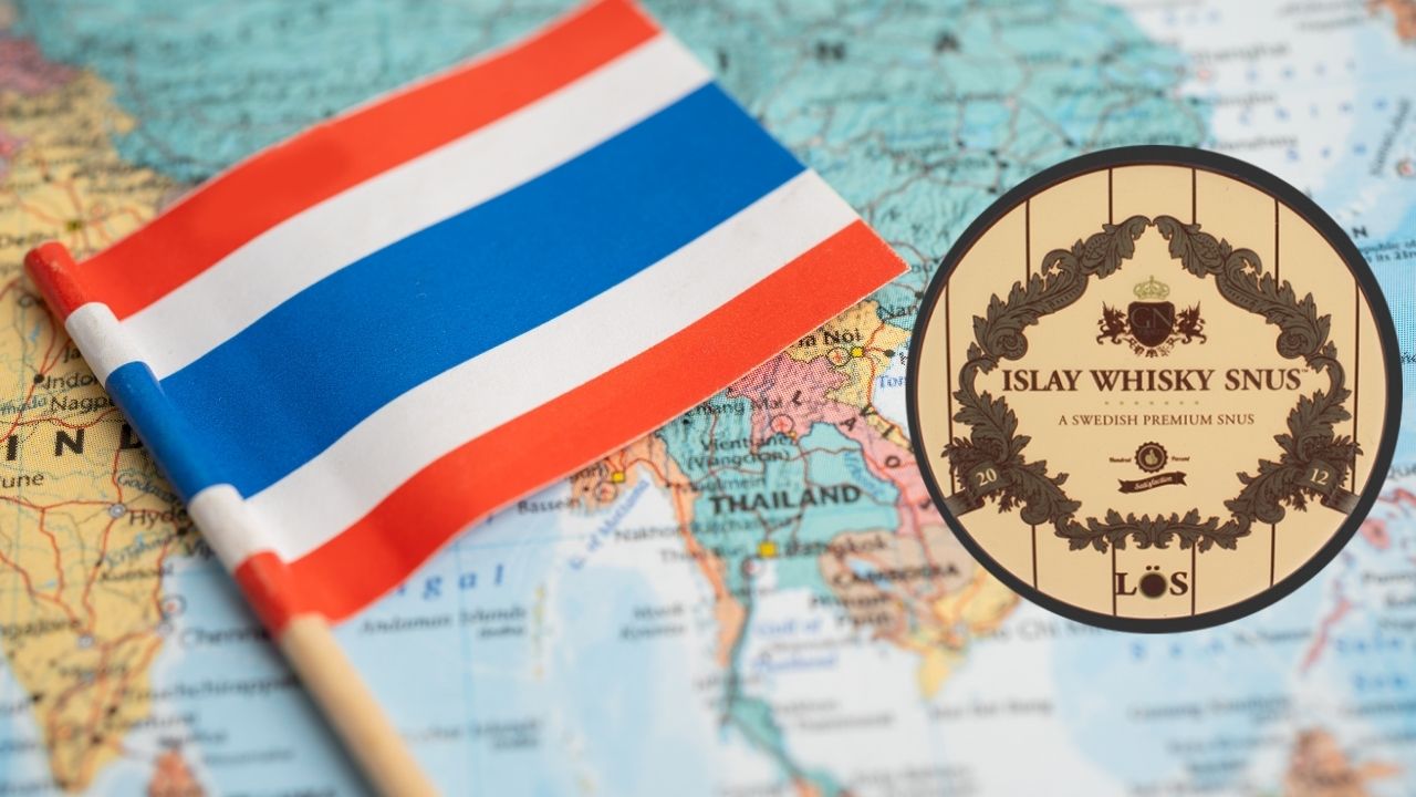 A map of Thailand with the Thai flag lying on top of it. On the right hand side of the flag is a tin of Islay Loose Snus.