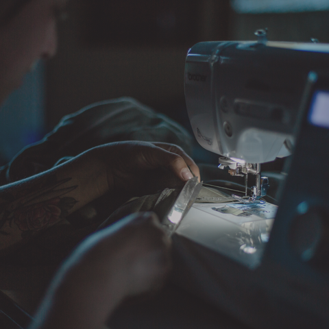 Arkeras artisan at sewing machine
