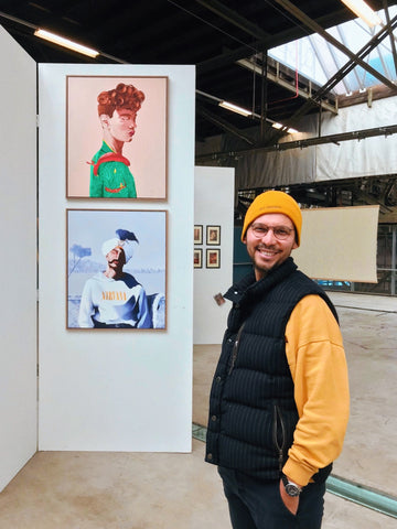 Ulas Uygun, Founder and head designer at WOO Branding is posing in front of his exhibition in Amsterdam. 