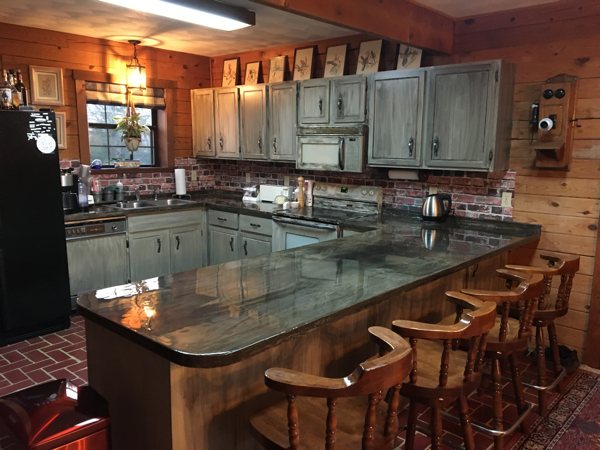 A softly lit kitchen with a full set of epoxy countertops.