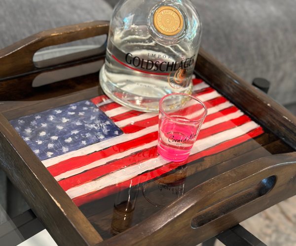 A wooden epoxy resin tray with American flag artwork sealed beneath a pristine epoxy finish using Primaloc Epoxy Resin.