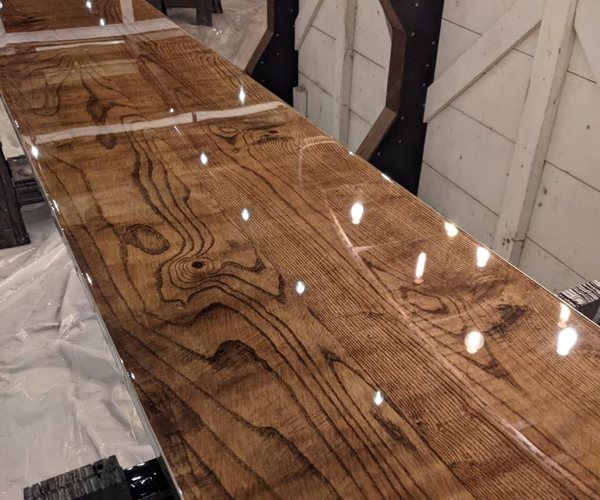 A wooden epoxy bar top with fresh flood coatings of epoxy.