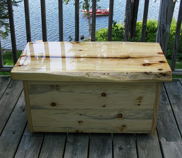 A wooden epoxy table top resting outdoors on a lakeside balcony.