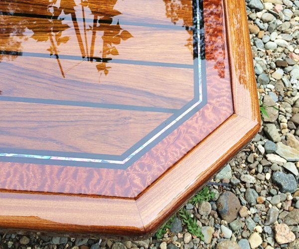 A close-up of a corner of a wooden epoxy table top with a perfectly mixed and poured resin finish.