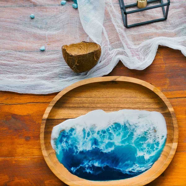 A wooden tray with an epoxy resin finish made to look like ocean waves by using blue and white mica powder pigments.